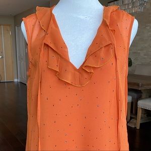 Short sleeved orange blouse with tiny blue speckles.